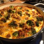 Nahaufnahme eines frisch gebackenen Brokkoli-Rahm-Auflaufs mit Hackfleisch und geschmolzenem Käse.