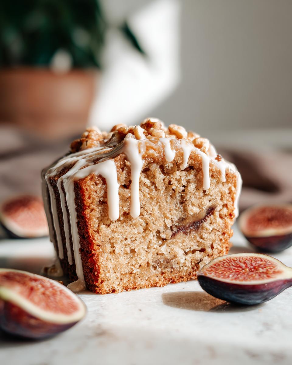 Ein Stück saftiger Feigen-Walnuss-Kuchen mit Zimtglasur, umgeben von frischen Feigenhälften.