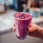 Nahaufnahme eines Frozen Yogurt Shake mit Waldbeeren, garniert mit frischen Beeren.