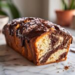 Ein Anschnitt von saftigem Marmorkuchen mit Schokoglasur, perfekt für den Kaffeetisch.