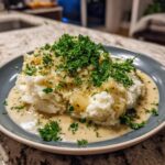 Ein Teller mit cremigem Rahm-Kohlrabi und Kartoffelstampf, garniert mit frischer Petersilie.