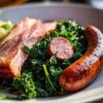 Nahaufnahme von Grünkohl mit Pinkel oder Kasseler, deftig und traditionell angerichtet.