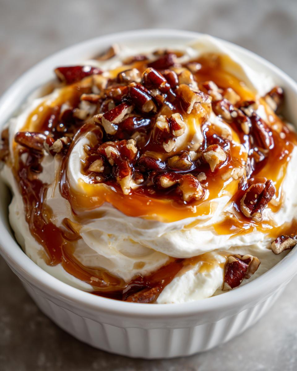 Nahaufnahme des cremigen Karamell Apfel Dip, getoppt mit Karamellsauce und gehackten Pekannüssen.