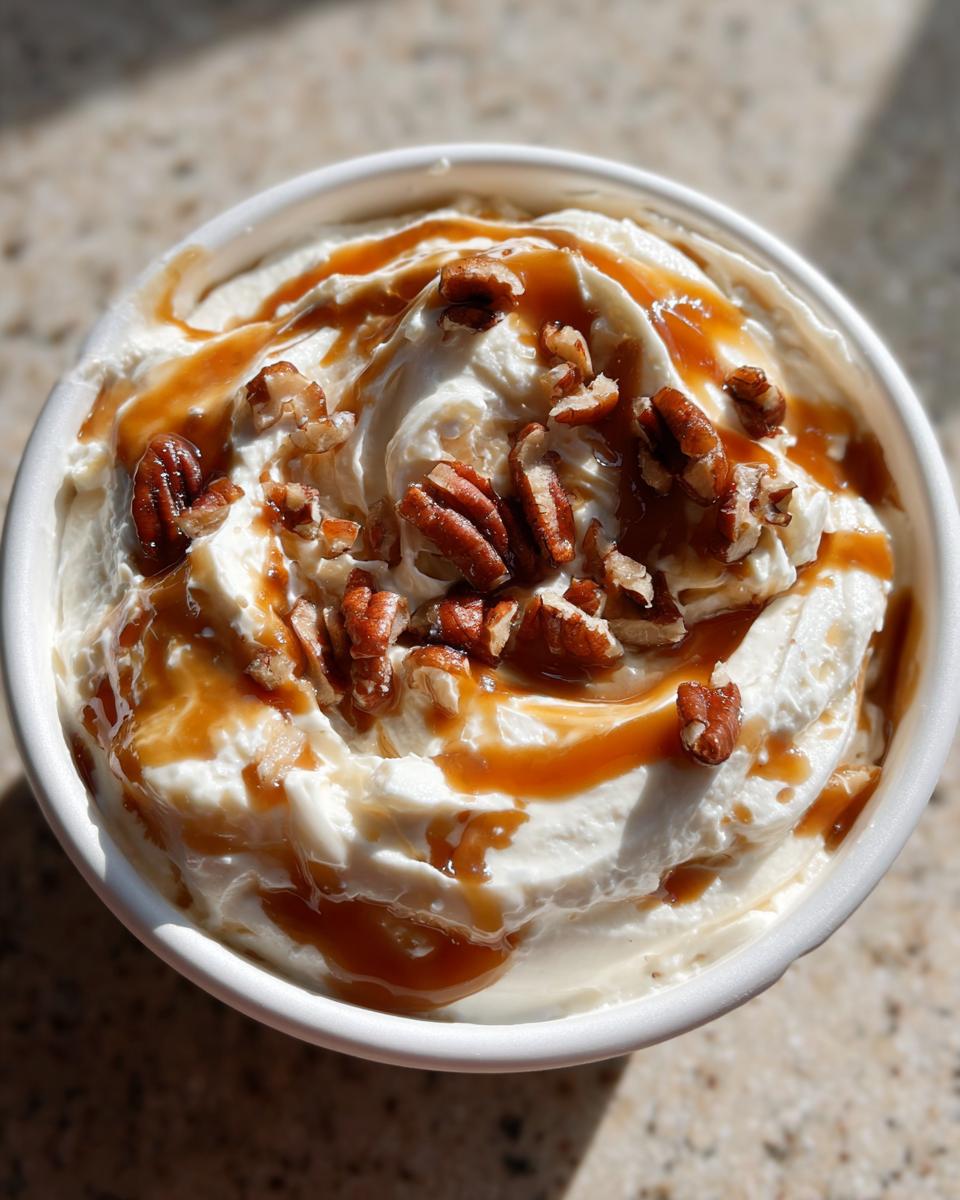 Nahaufnahme vom fertigen Karamell Apfel Dip, getoppt mit Karamellsauce und gehackten Pekannüssen.