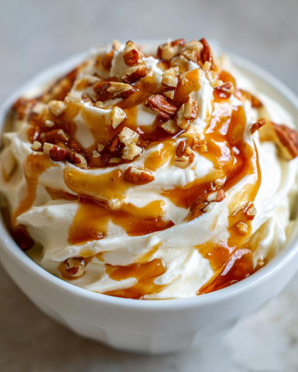 Nahaufnahme des cremigen Karamell Apfel Dip, übergossen mit Karamellsauce und gehackten Pekannüssen.