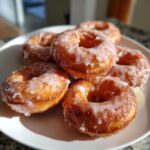 Nahaufnahme von fluffigen, glasierten Mochi Donuts, die appetitlich auf einem weißen Teller angerichtet sind.