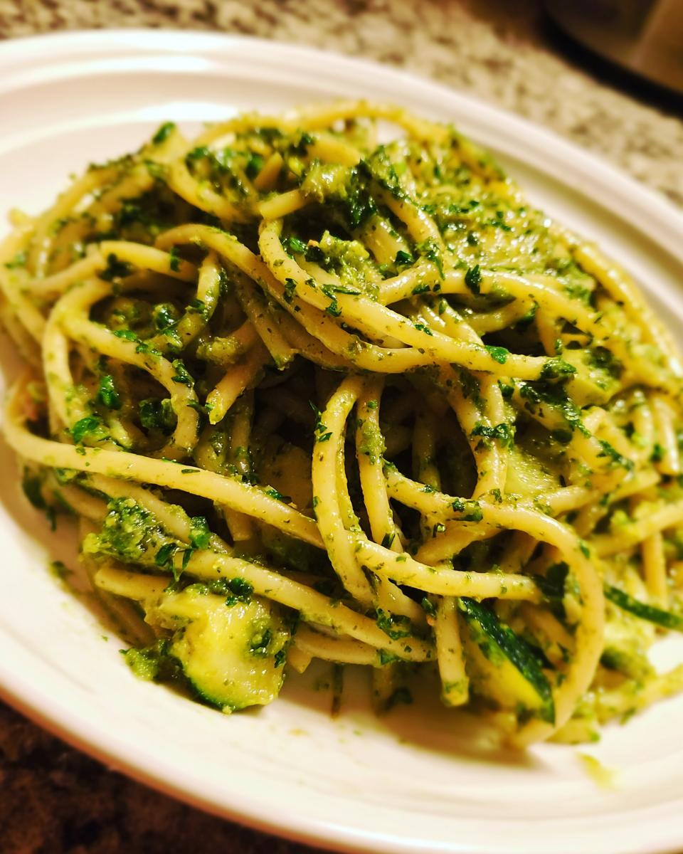 Eine Teller Pasta mit Zucchini und Kräuterrahm, üppig garniert mit frischen Kräutern.
