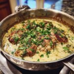 Schweinemedaillons in cremiger Rahmsauce, garniert mit frischer Petersilie, in einer Pfanne serviert.