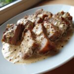 Aufgeschnittenes Gyros-Geschnetzeltes in Sahnesauce auf einem weißen Teller, perfekt für den schnellen Genuss.