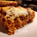 Nahaufnahme eines großen Stücks Kritharaki-Auflauf mit Hackfleisch und geschmolzenem Käse.