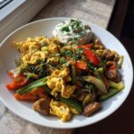 Bunte Protein-Gemüsepfanne mit Rührei, Gemüse und einem Klecks Quark-Dip.