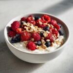 Nahaufnahme einer cremigen Skyr-Bowl mit Haferflocken, Himbeeren und Blaubeeren – perfekt für die Skyr-Bowl mit Haferflocken.