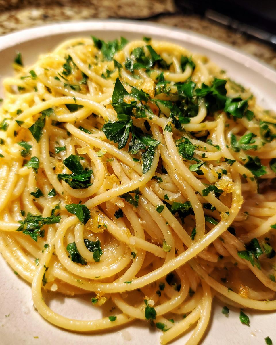 Nahaufnahme von perfekt al dente gekochten Nudeln mit Butter, Knoblauch und frischer Petersilie.