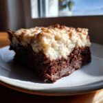 Ein saftiges Stück Milchreis-Brownies mit einer dicken, cremigen Milchreis-Schicht auf dunklem Schokoboden.