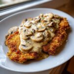 Goldbraun paniertes Schnitzel übergossen mit cremiger Champignonrahmsauce.