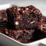 Nahaufnahme von einem saftigen Stück Triple-Chocolate-Baked-Oats mit Schokostückchen.