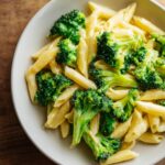 Nahaufnahme von cremiger Brokkoli-Käse-Pasta mit Penne und leuchtend grünen Brokkoliröschen.