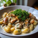 Nahaufnahme von Gnocchi mit Hähnchen und Parmesanrahm, garniert mit frischer Petersilie.