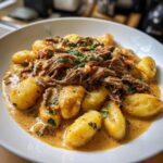 Teller mit cremigen Gnocchi, üppig belegt mit zarten Rinderstreifen in Pfefferrahmsoße.