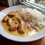 Teller mit saftigem Gyrosgeschnetzeltes in cremiger Metaxasauce und lockerem Reis.