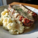 Zwei Scheiben saftiger Hackbraten mit cremiger Rahmsauce und lockerem Kartoffelpüree.