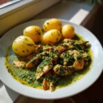 Teller mit Hähnchengeschnetzeltes mit Kräuterrahm und Pellkartoffeln, appetitlich angerichtet.