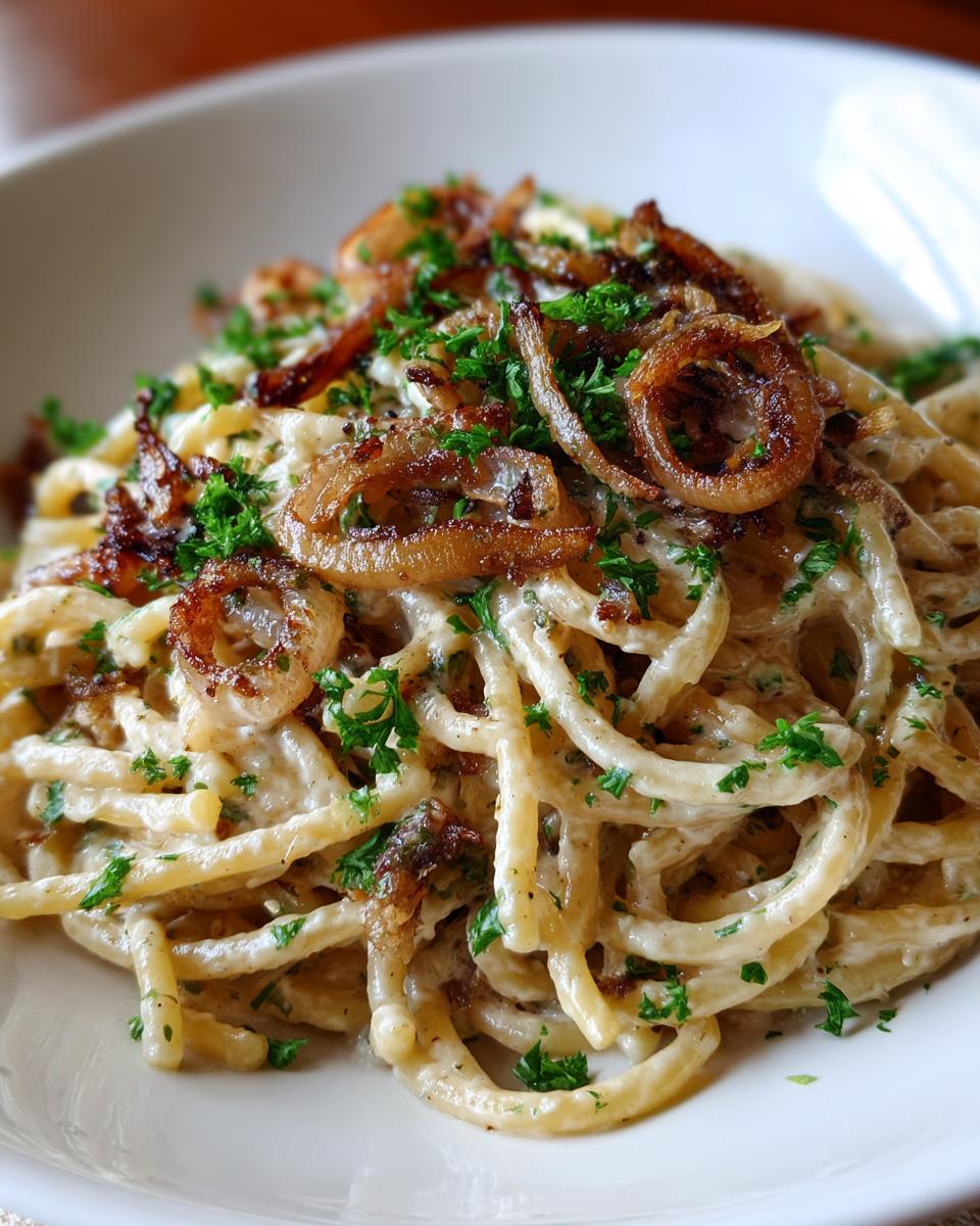 Cremige Pasta mit Zwiebel-Sahnesauce, garniert mit knusprigen Röstzwiebeln und Petersilie.