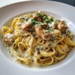 Köstliche Tagliatelle mit Hähnchen in Kräutersahne, üppig bedeckt mit cremiger Sauce und frischer Petersilie.